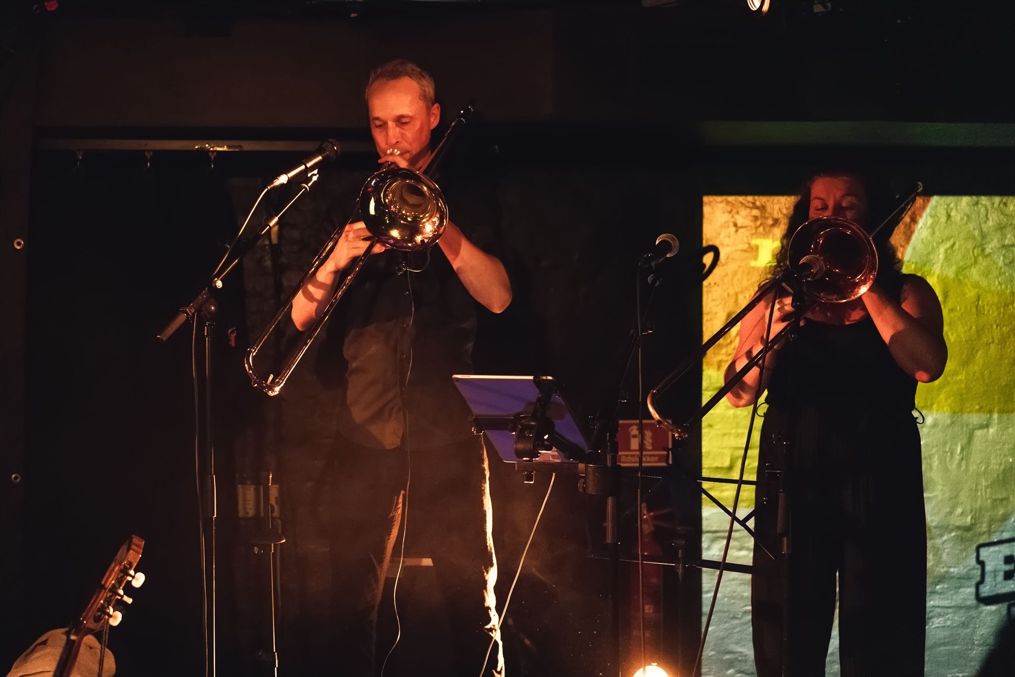 A trombonist and a trumpeter playing side by side.
